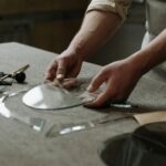 Close-up of artisan hands crafting glass pieces in a workshop, showcasing skill and precision.